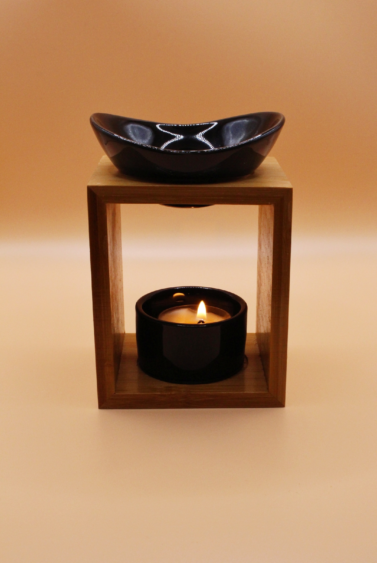 Bruleur pour bougie noir avec un fond orange